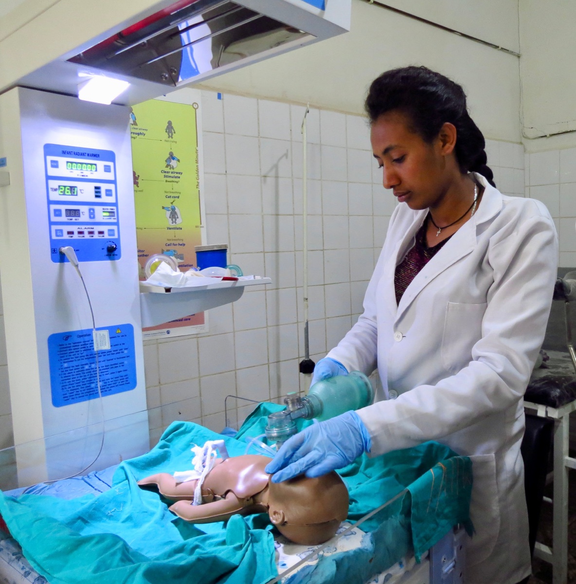 Profesional practicando reanimación neonatal con un maniquí clínico